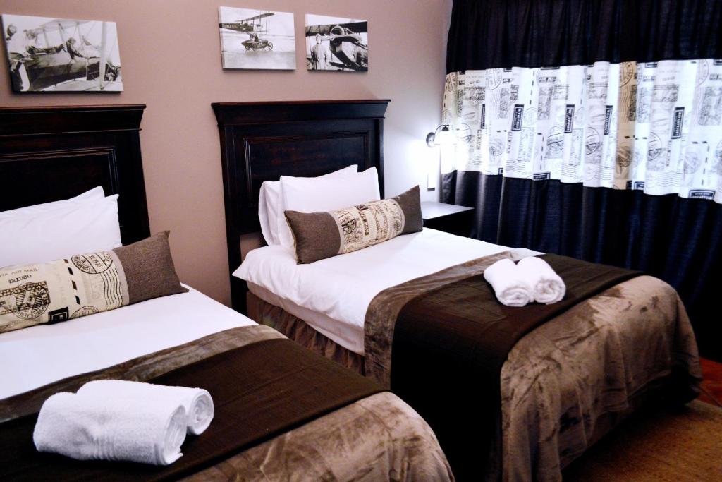 a hotel room with two beds with towels on them at Barnstormers Rest in Malelane