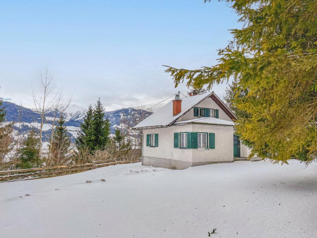 a white house with green windows in the snow at Holiday Home Landhaus Grüne Oase by Interhome in Sankt Martin am Grimming