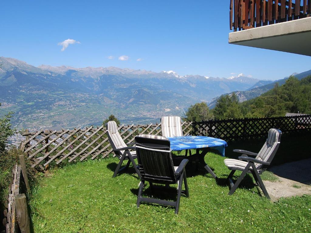 a table and chairs with a view of the mountains at Apartment Bellevue L by Interhome in Veysonnaz