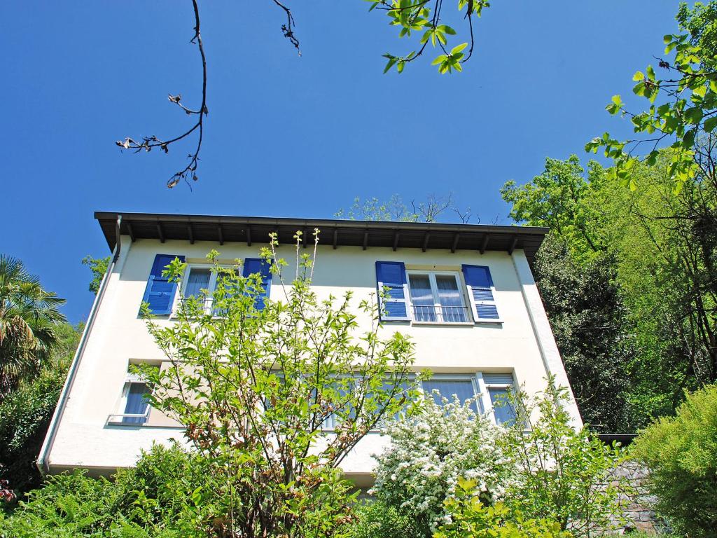 un edificio blanco con ventanas y árboles azules en Holiday Home Christa by Interhome, en Bissone
