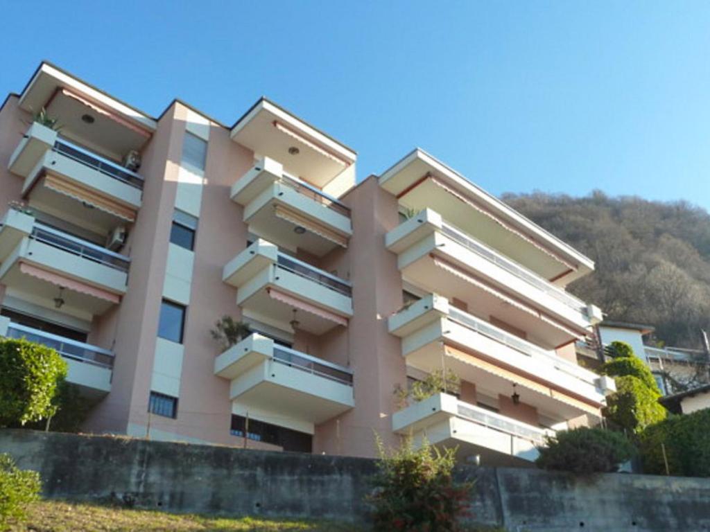 un edificio rosa con balcones en un lateral en Apartment Superpanorama II by Interhome, en Viganello