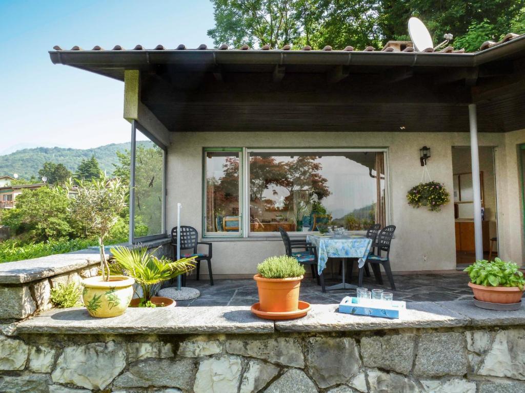 eine Terrasse mit einem Tisch, Stühlen und Pflanzen in der Unterkunft Holiday Home Cityview Lugano - Casa Carlo by Interhome in Cadro