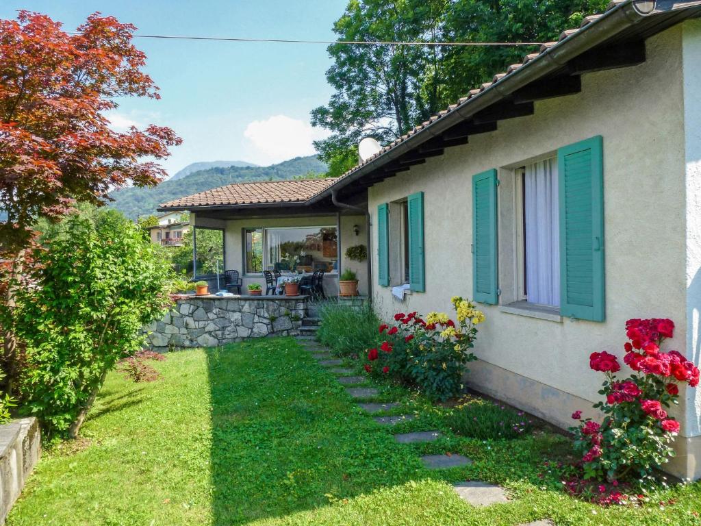 ein Haus mit grünen Rollläden und einem Hof in der Unterkunft Holiday Home Cityview Lugano - Casa Carlo by Interhome in Cadro