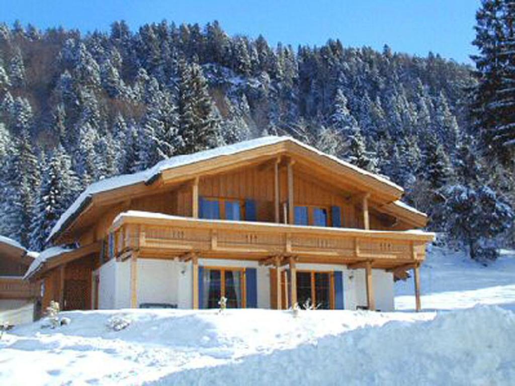 a large wooden house in the snow with trees at Holiday Home Chalet Chiemsee by Interhome in Sachrang