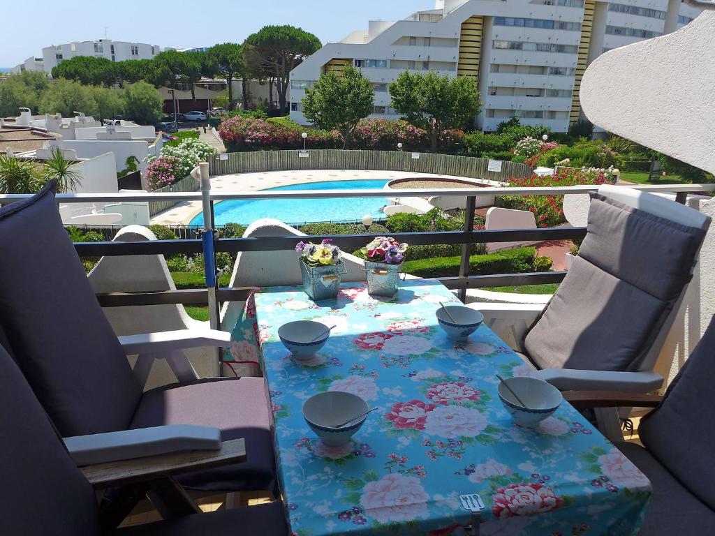 a table with flowers on it on a balcony at Apartment Du Soleil-2 by Interhome in La Grande Motte