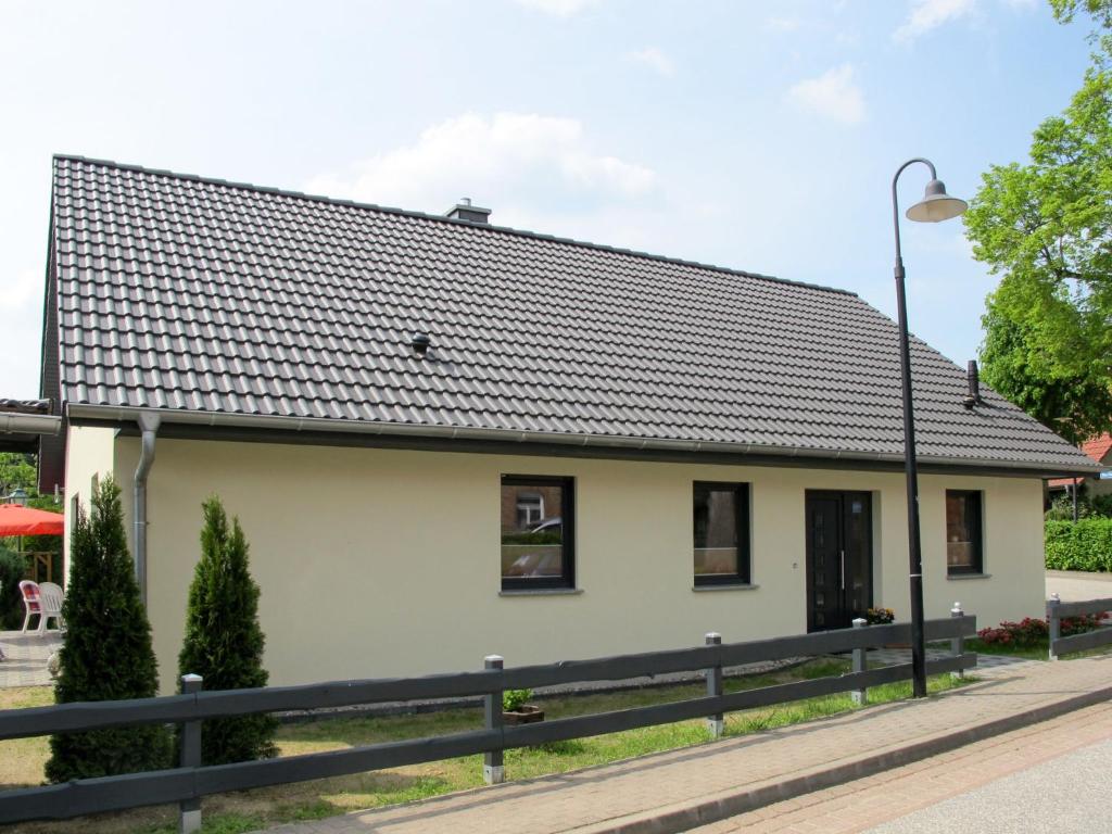 a small white house with a black roof at Holiday Home Johannika by Interhome in Godern