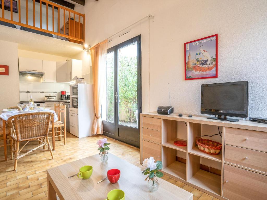 uma sala de estar com televisão e uma cozinha em Holiday Home Les Maisons de la Plage-8 by Interhome em Le Grau-du-Roi