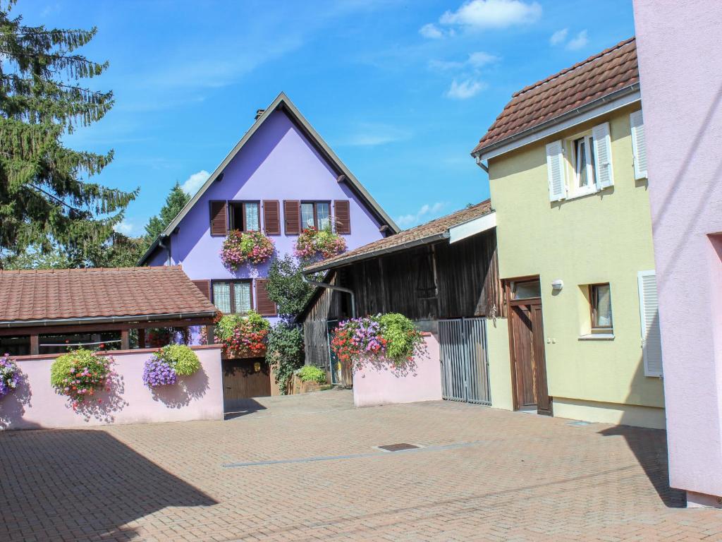 a house with flowers in the courtyard at Apartment Résidence jaune et rose-1 by Interhome in Marckolsheim