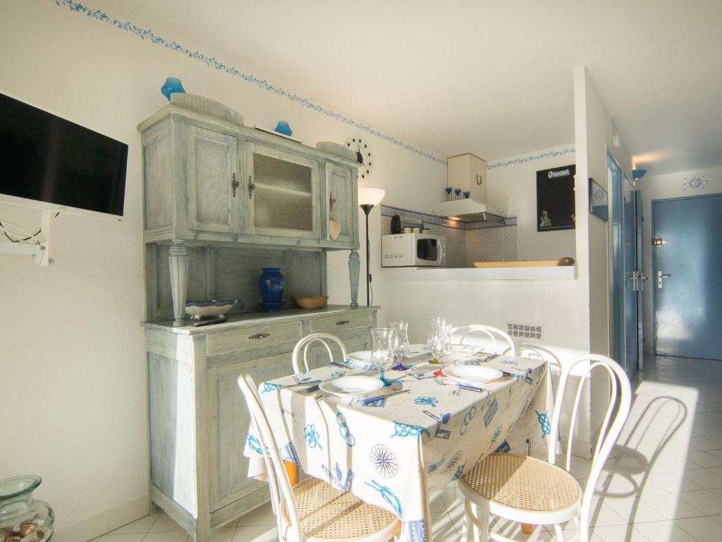 une cuisine avec une table, des chaises et une armoire dans l'établissement Studio Ulysse Plage-12 by Interhome, à La Grande Motte