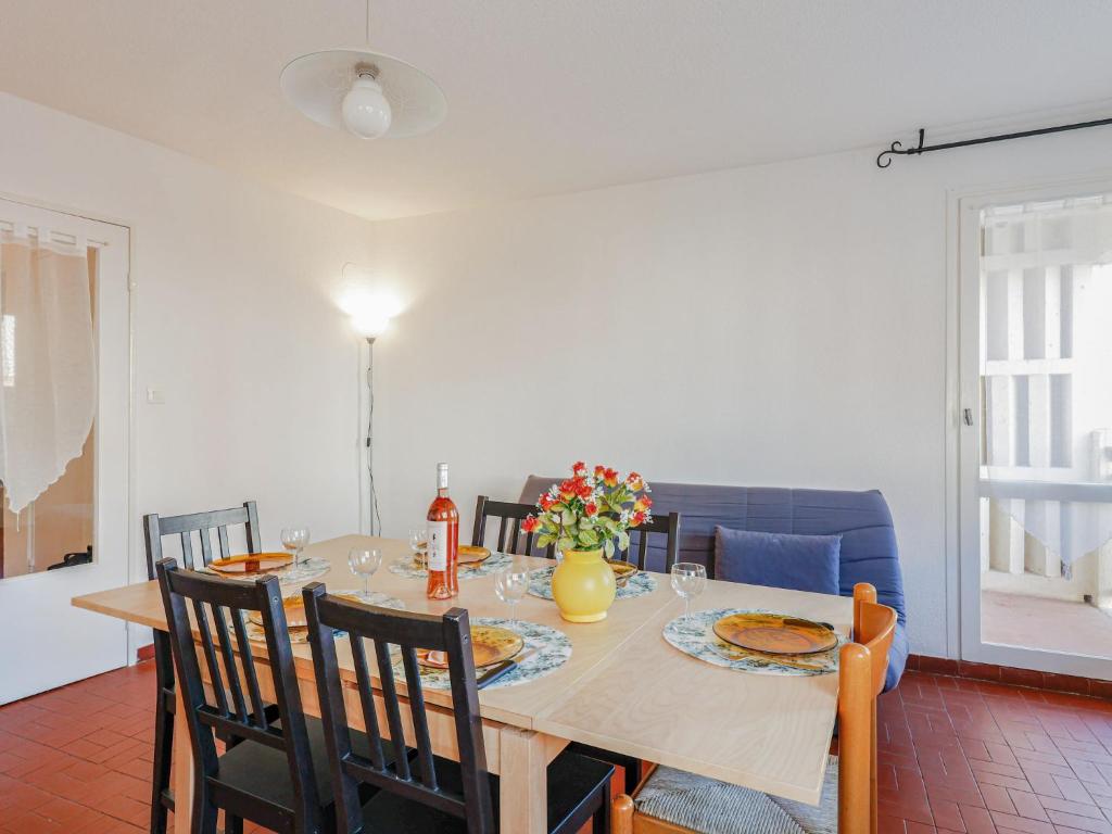 a dining room with a table with chairs and a table at Apartment Mare Nostrum by Interhome in Cap d'Agde