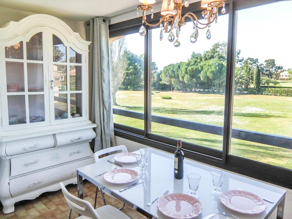 una sala da pranzo con tavolo e una grande finestra di Apartment Les Catalanes du Golf by Interhome a Saint-Cyprien