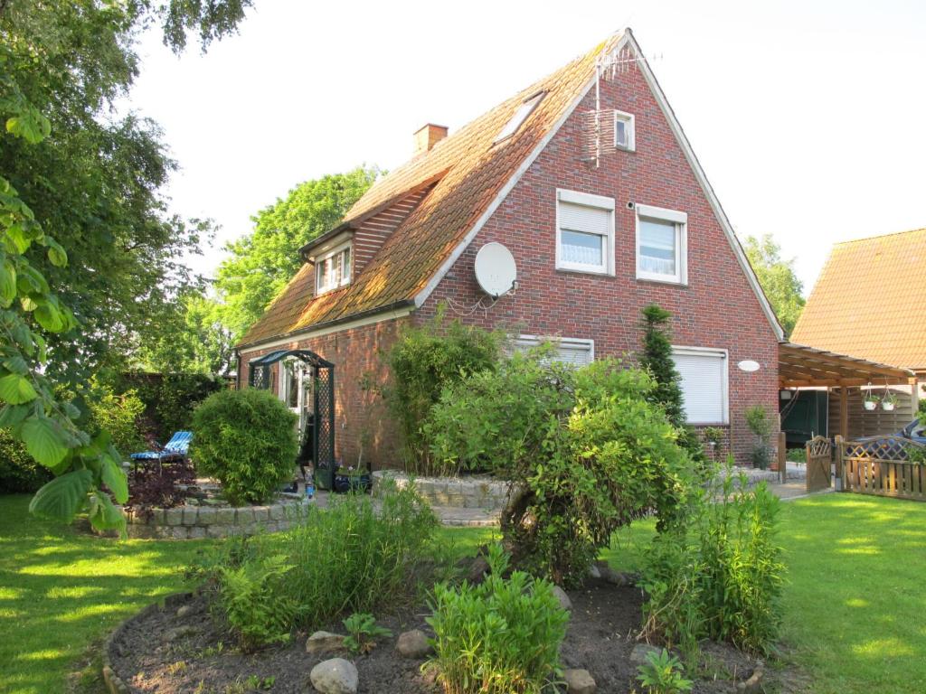 een rood bakstenen huis met een tuin in de tuin bij Apartment Haus am See by Interhome in Hohenkirchen