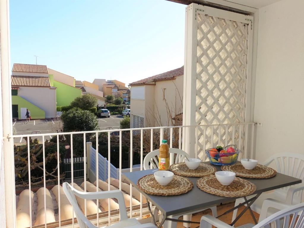 d'une table et de chaises sur un balcon avec vue sur la rue. dans l'établissement Apartment Les Balcons de la Méditerranée-16 by Interhome, à Narbonne-Plage