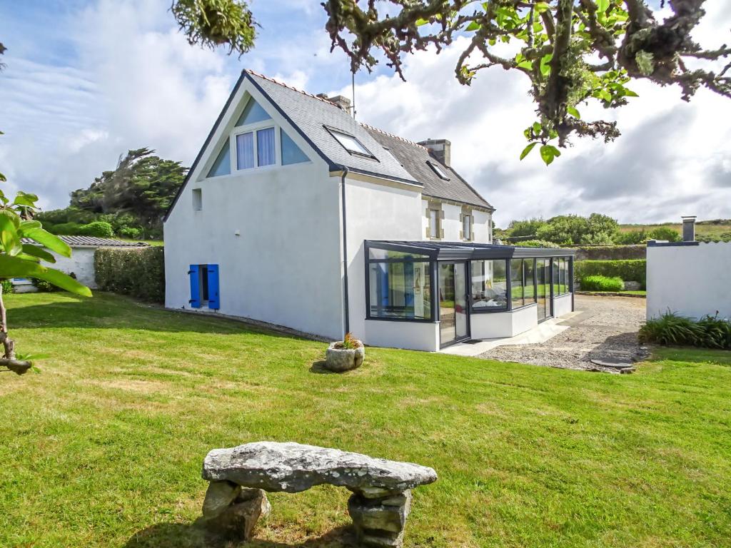 une maison blanche avec des portes en verre et une cour verdoyante dans l'établissement Holiday Home Kerludu by Interhome, à Kerloch