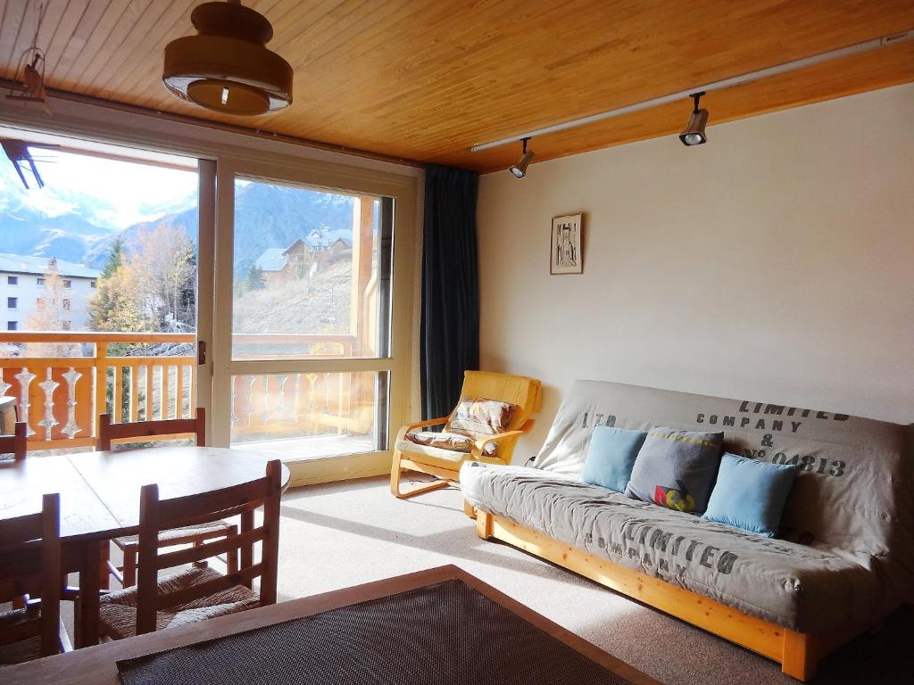 a living room with a couch and a table at Apartment Le Super Venosc by Interhome in Les Deux Alpes