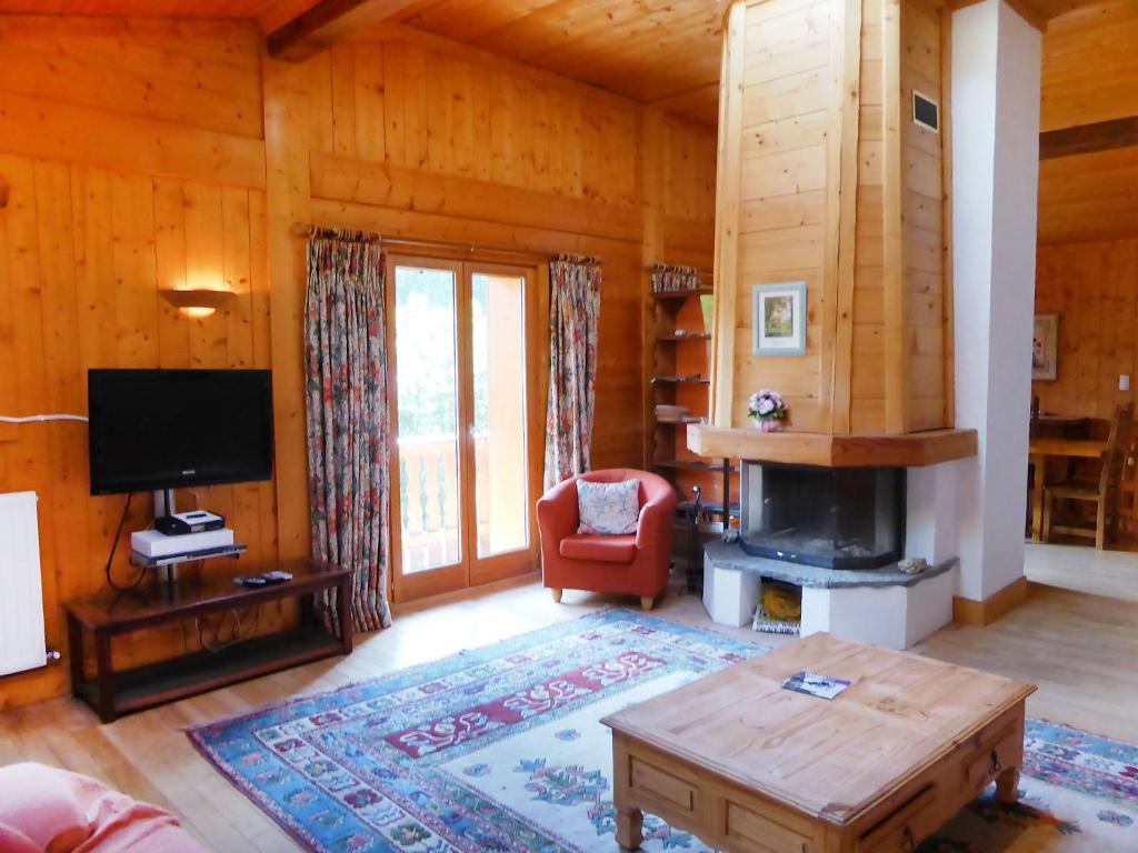 a living room with a fireplace and a tv at Apartment Les Moranches by Interhome in Les Contamines-Montjoie