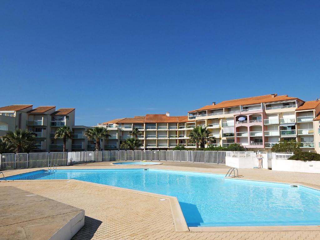 a swimming pool in front of a apartment building at Apartment Les Goelettes-8 by Interhome in Saint-Cyprien-Plage