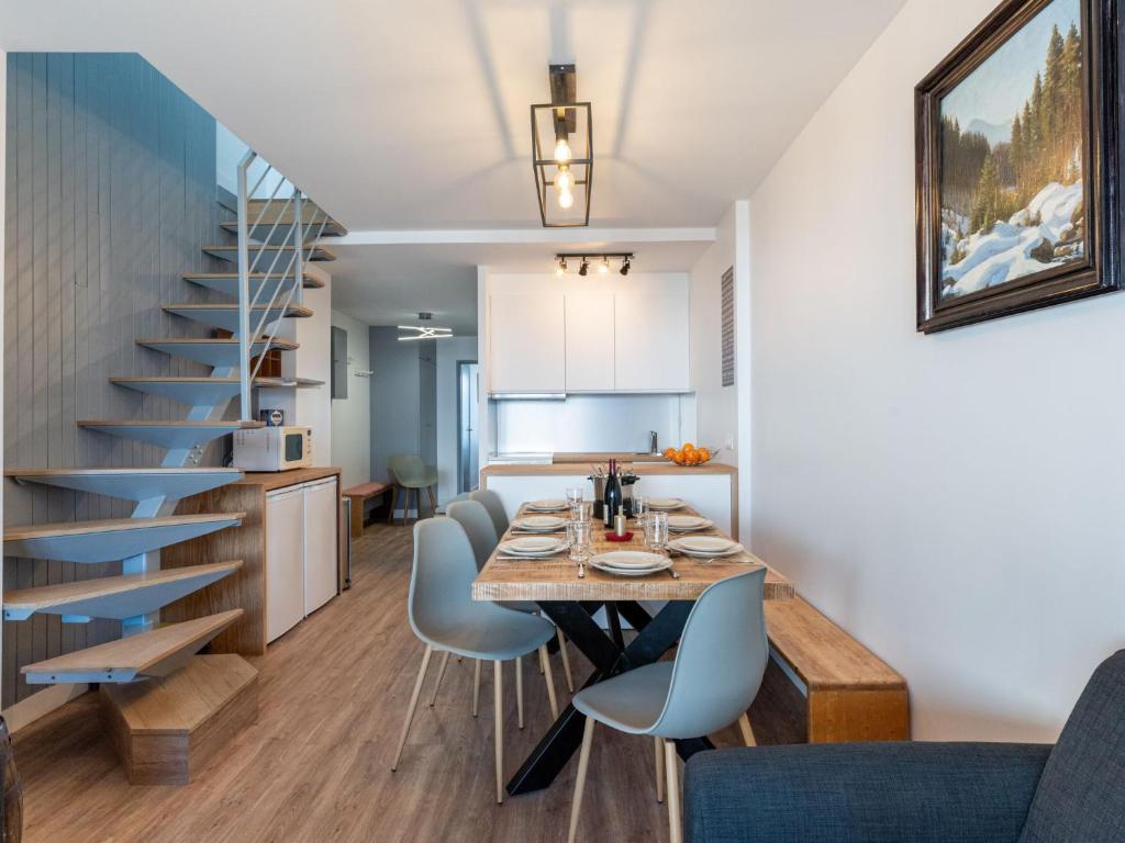 a kitchen and dining room with a table and a staircase at Apartment Le Curling A-9 by Interhome in Tignes