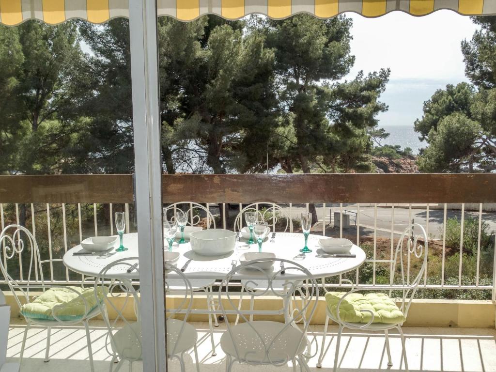 d'une table et de chaises blanches sur un balcon. dans l'établissement Apartment La Calanque d'Or by Interhome, à Bandol