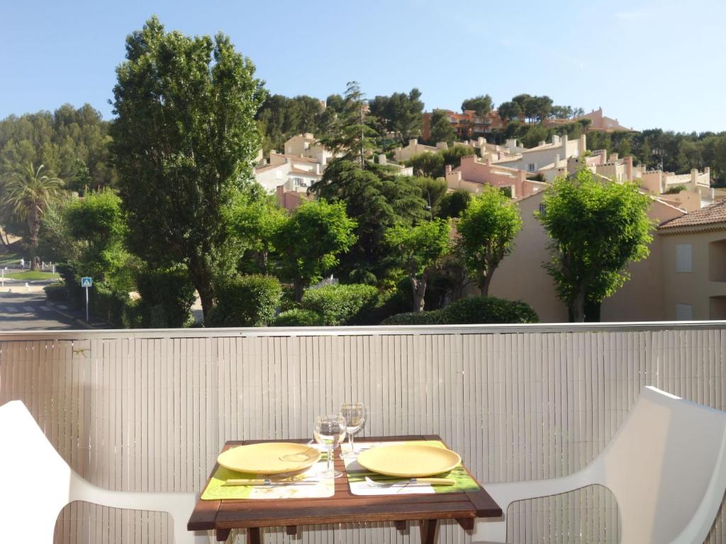 a table with two chairs and glasses on a balcony at Apartment Les Aigues Marines-36 by Interhome in La Madrague