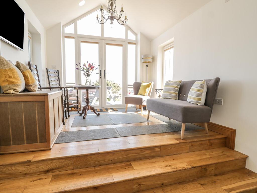 a living room with a couch and a table with chairs at Marsh Villa in Skinburness