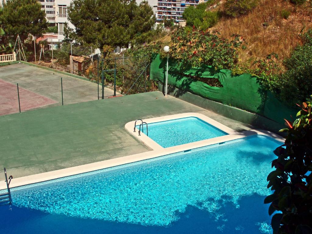 una pequeña piscina con pista de tenis y una pista de tenis en Apartment Don Miguel III by Interhome, en Cala de Finestrat