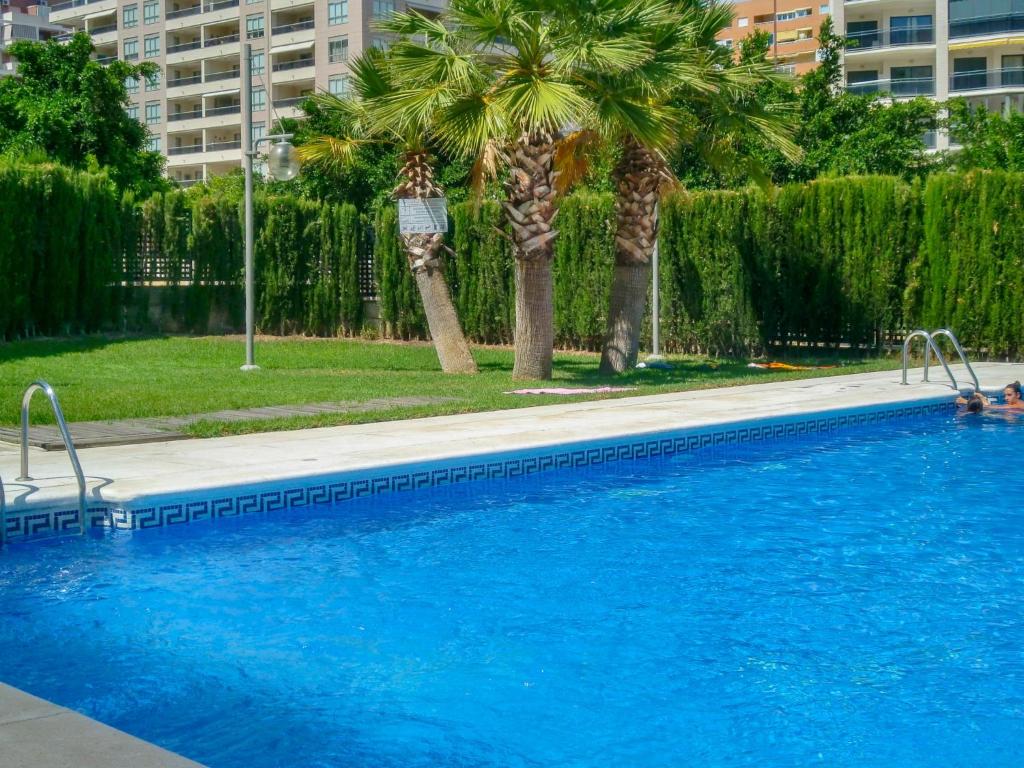 una piscina con palmeras en una ciudad en Apartment Sidney by Interhome, en Cala de Finestrat