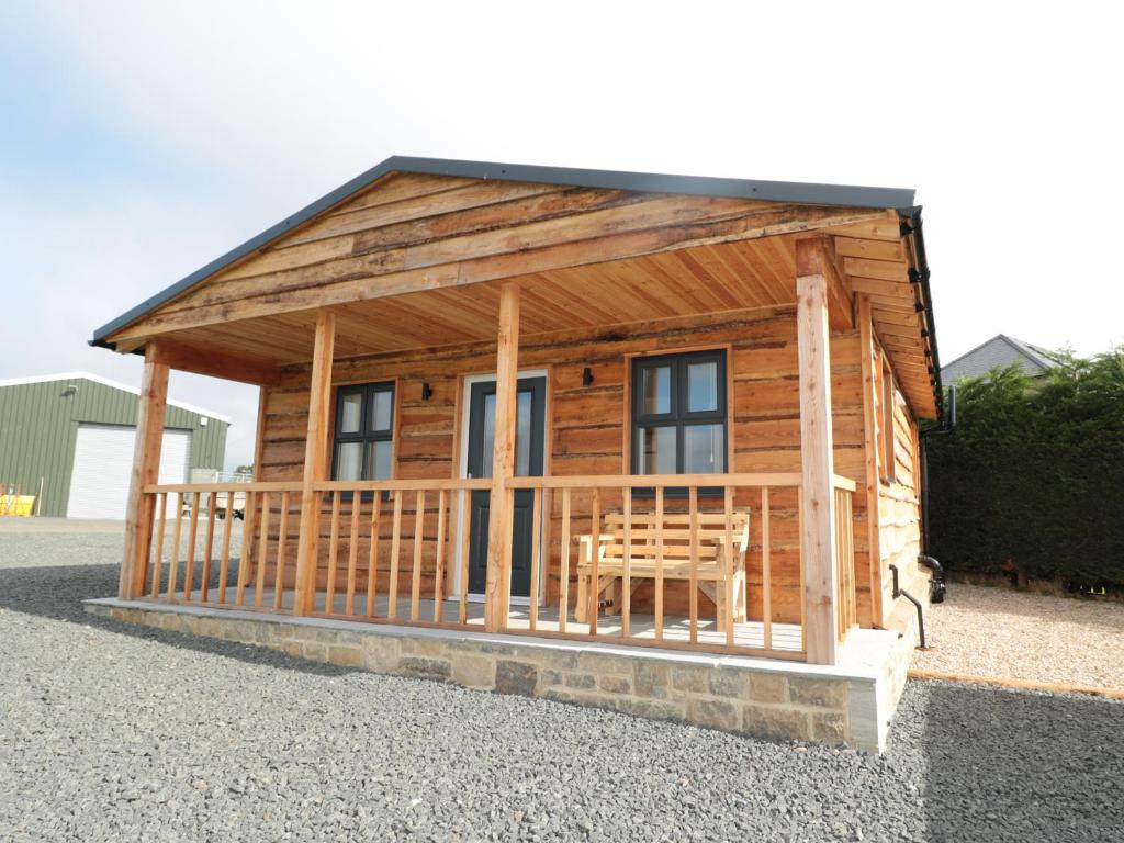 a small log cabin with a table in it at Aln in Longframlington