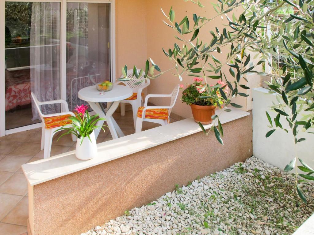 une terrasse avec une table, des chaises et des plantes dans l'établissement Apartment Vivoda - PUL168 by Interhome, à Štinjan