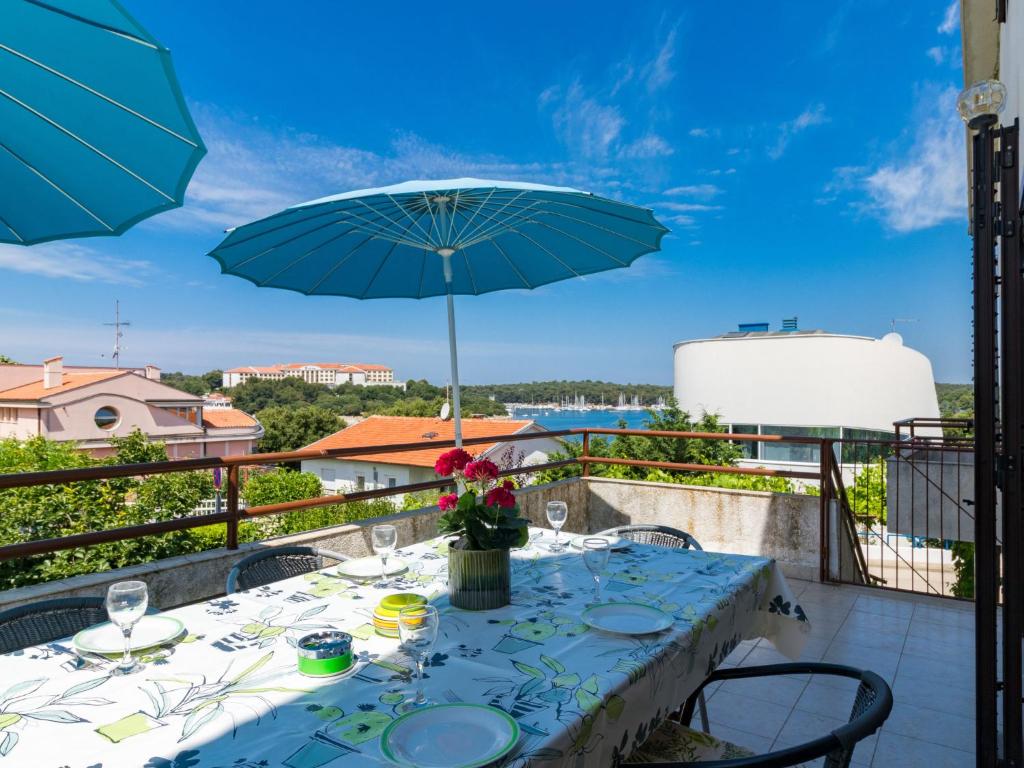 - une table avec un parasol sur le balcon dans l'établissement Apartment Bellevue - PUL331 by Interhome, à Pješčana Uvala