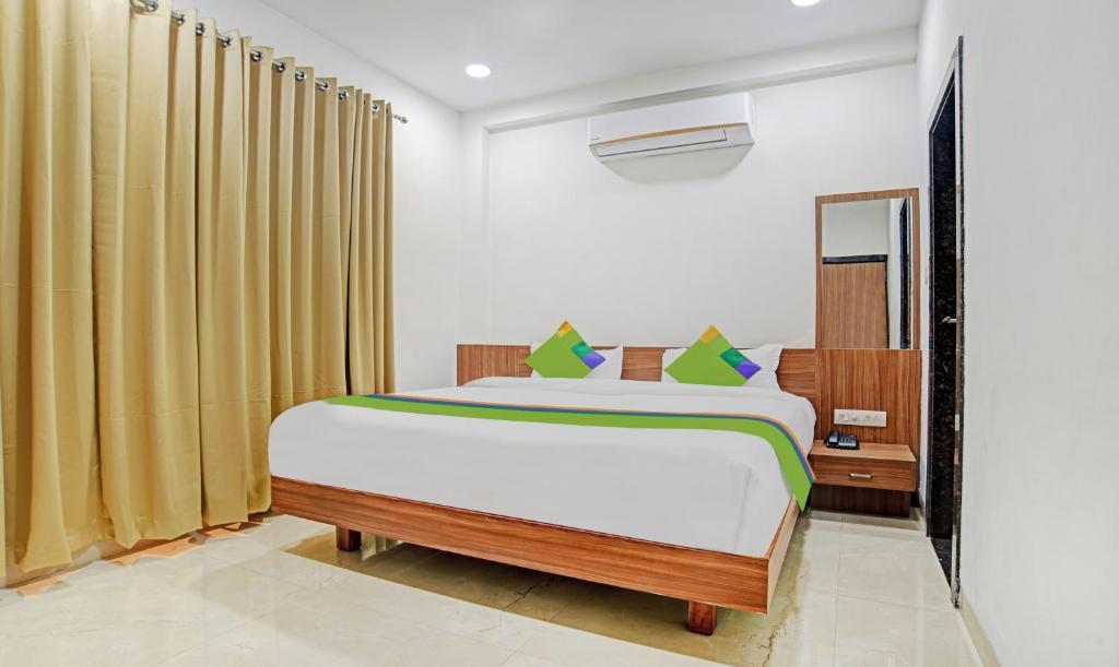 a bedroom with a large bed and a mirror at Treebo Trend Shivaay in Indore
