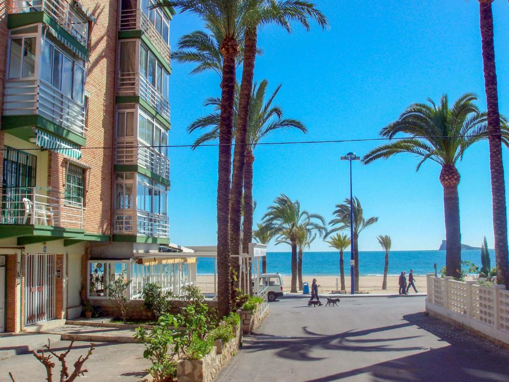ベニドルムにあるApartment Turia Playa by Interhomeのヤシの木と海の浜辺の建物