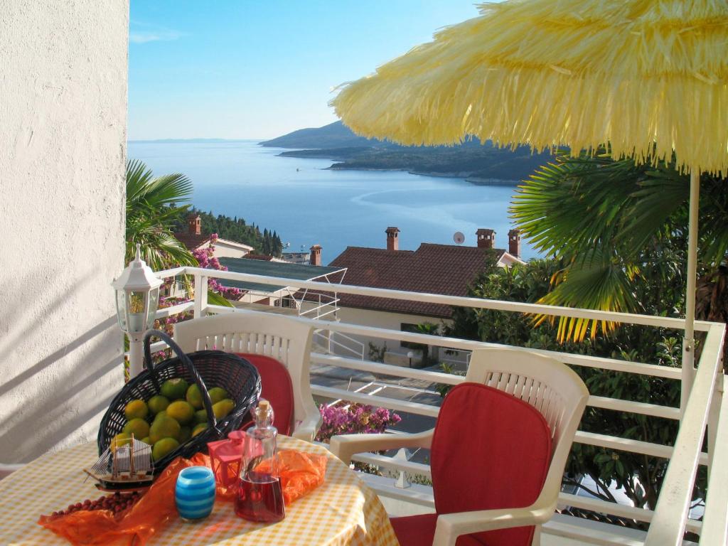 einen Tisch und Stühle auf einem Balkon mit Meerblick in der Unterkunft Apartment Palma - RAC108 by Interhome in Rabac