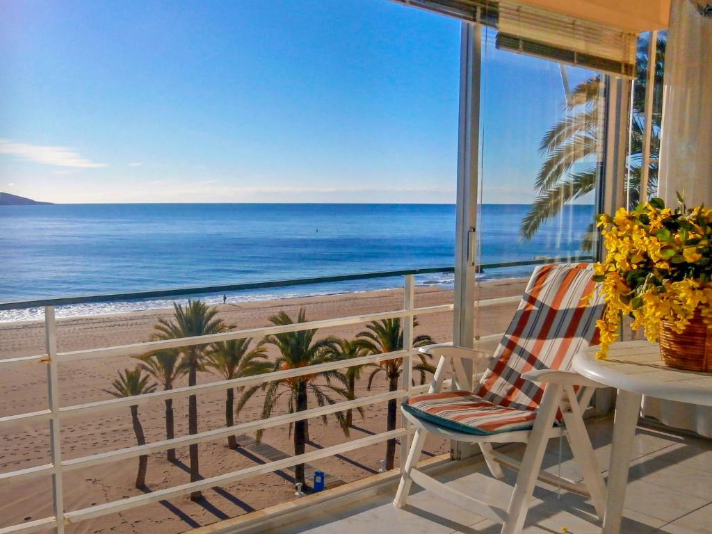 una sedia su un balcone con vista sulla spiaggia di Apartment Turia Playa by Interhome a Benidorm