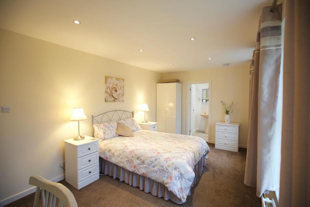a bedroom with a bed with two night stands and two lamps at Waterfall Cottage in Launceston