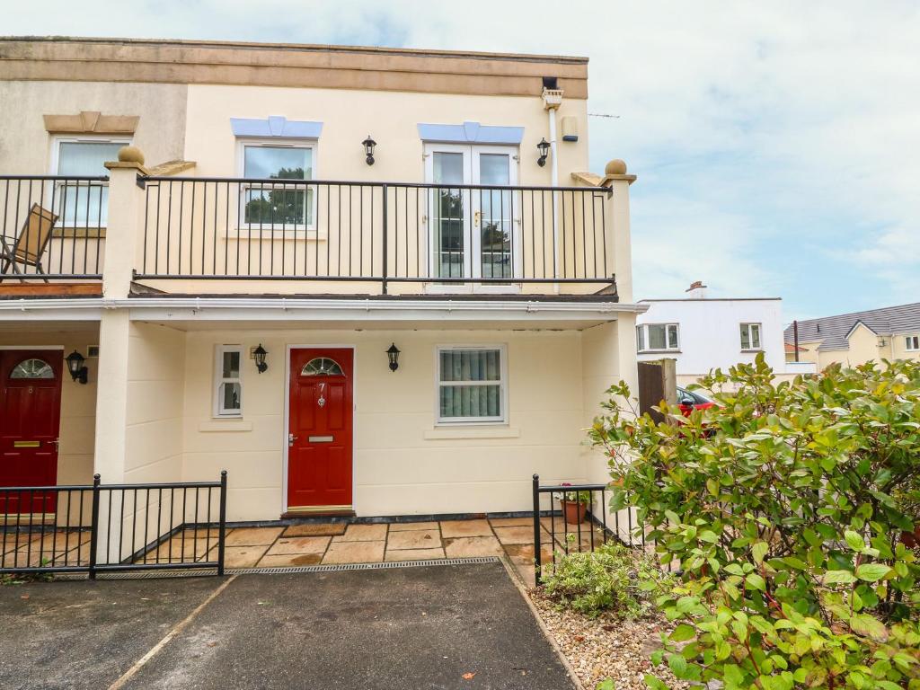 a house with a red door and a balcony at 7 The Retreat in Paignton