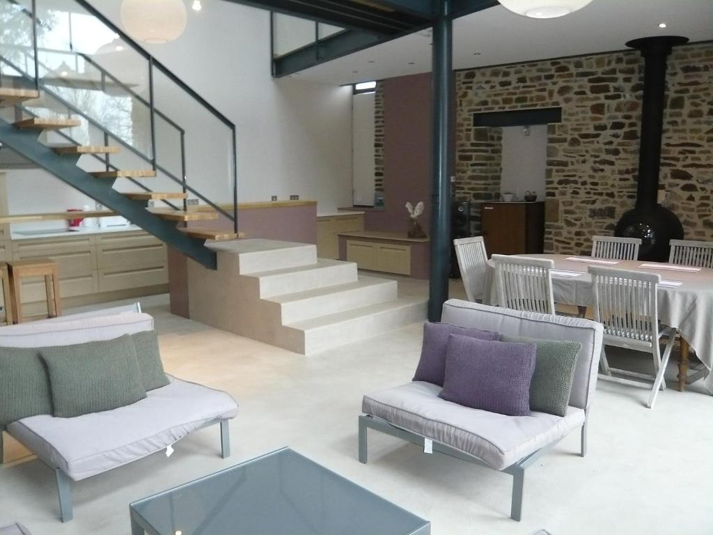 ジュルヴィル・レ・パンにあるHoliday Home La Gicquelière by Interhomeのリビングルーム(階段、椅子、テーブル付)