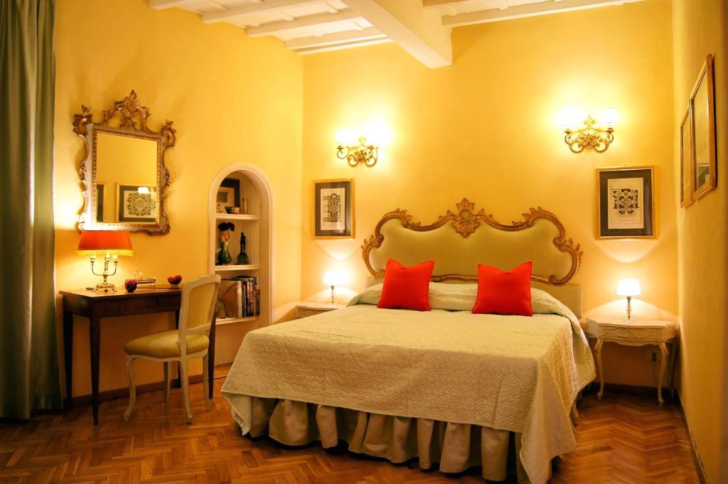 a bedroom with a bed with two red pillows at Trebbio in Florence