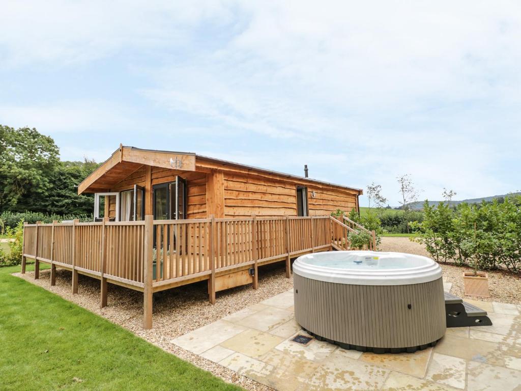 a wooden cabin with a hot tub in the yard at Mallard in Ross on Wye