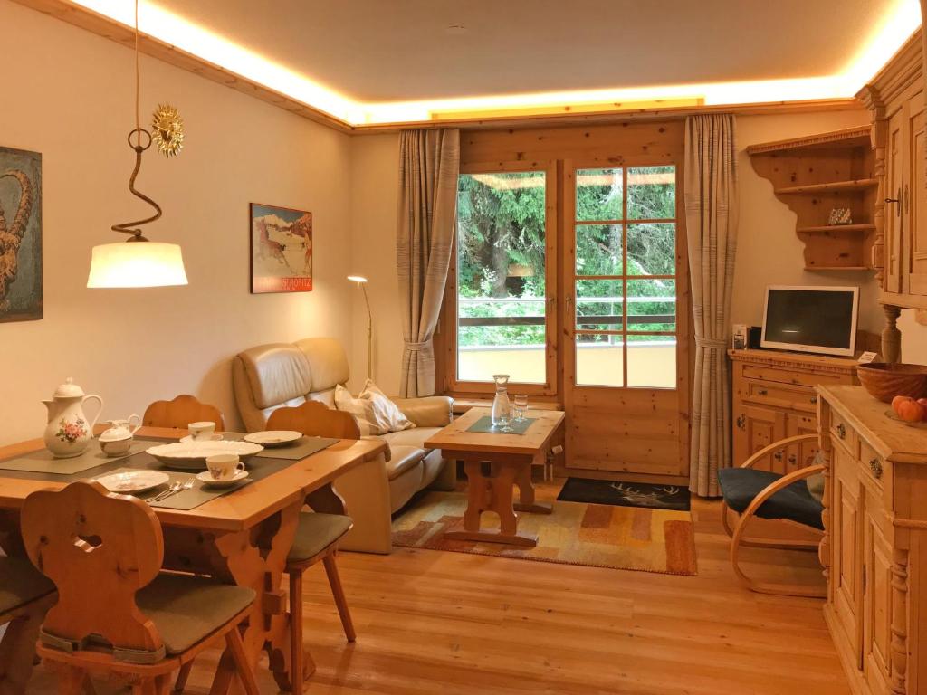 ein Wohnzimmer mit einem Tisch und einem Sofa in der Unterkunft Apartment Chesa Alvetern 5 by Interhome in Sils Maria