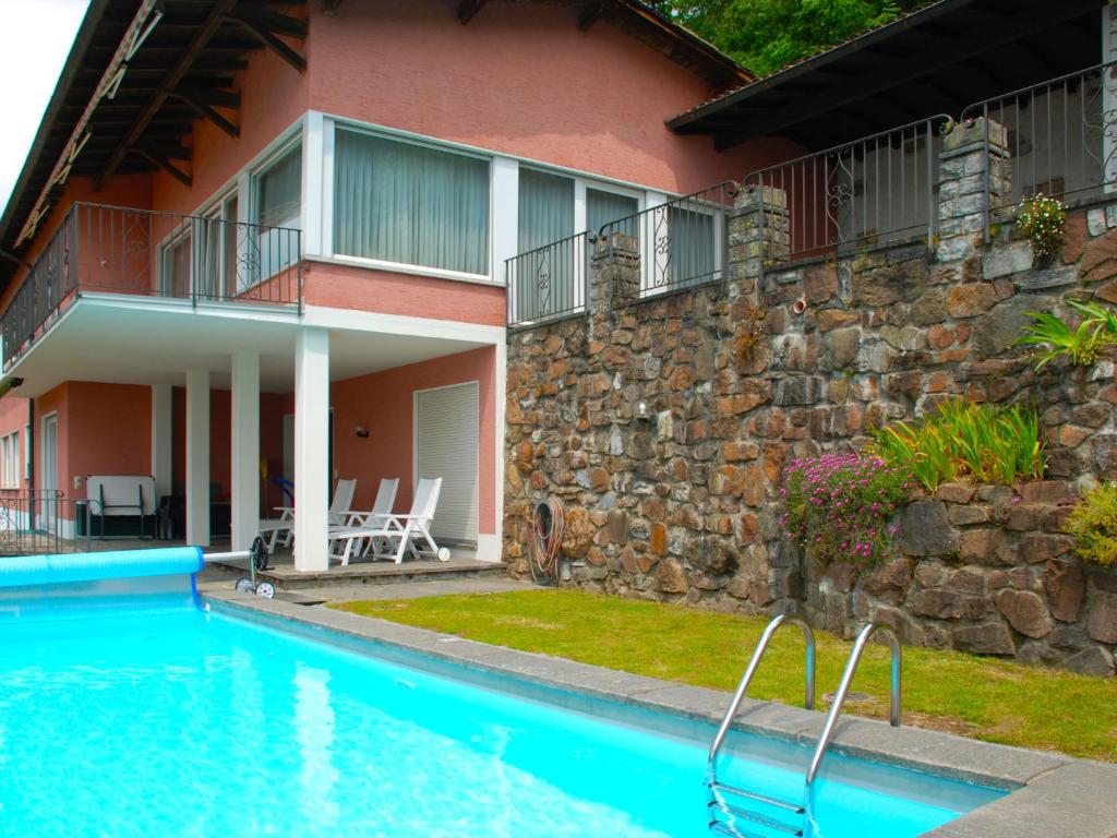 una casa con piscina al lado de un edificio en Apartment Bissonella by Interhome, en Bissone
