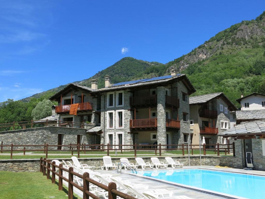 a house with a swimming pool in front of a mountain at Apartment Casa del Ponte - SMY612 by Interhome in Sampeyre