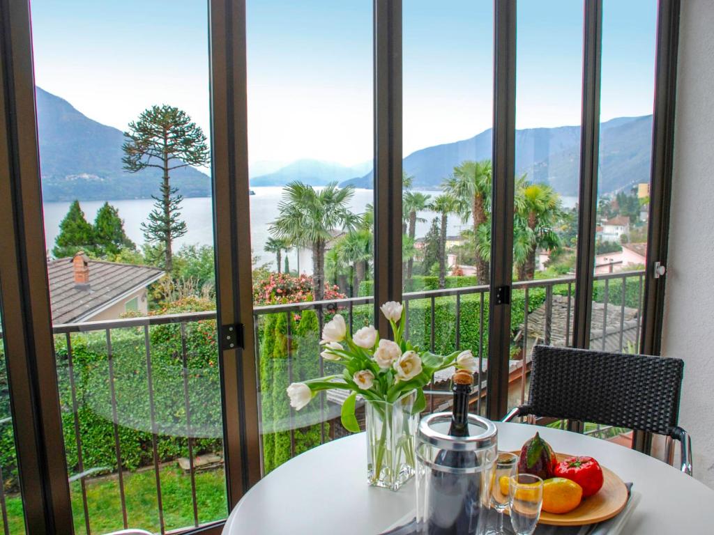 una mesa con una bandeja de fruta y flores en el balcón en Holiday Home Stellina del Sole by Interhome, en Brissago