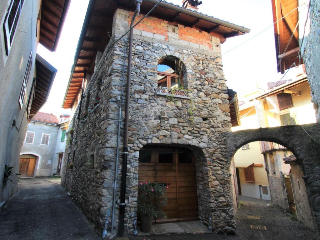 a stone building with a door and a window at Holiday Home Caa de Sass by Interhome in Castelveccana