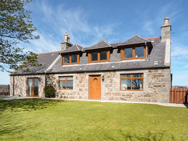 a large stone house with a large yard at Schoolhill Croft in Collieston
