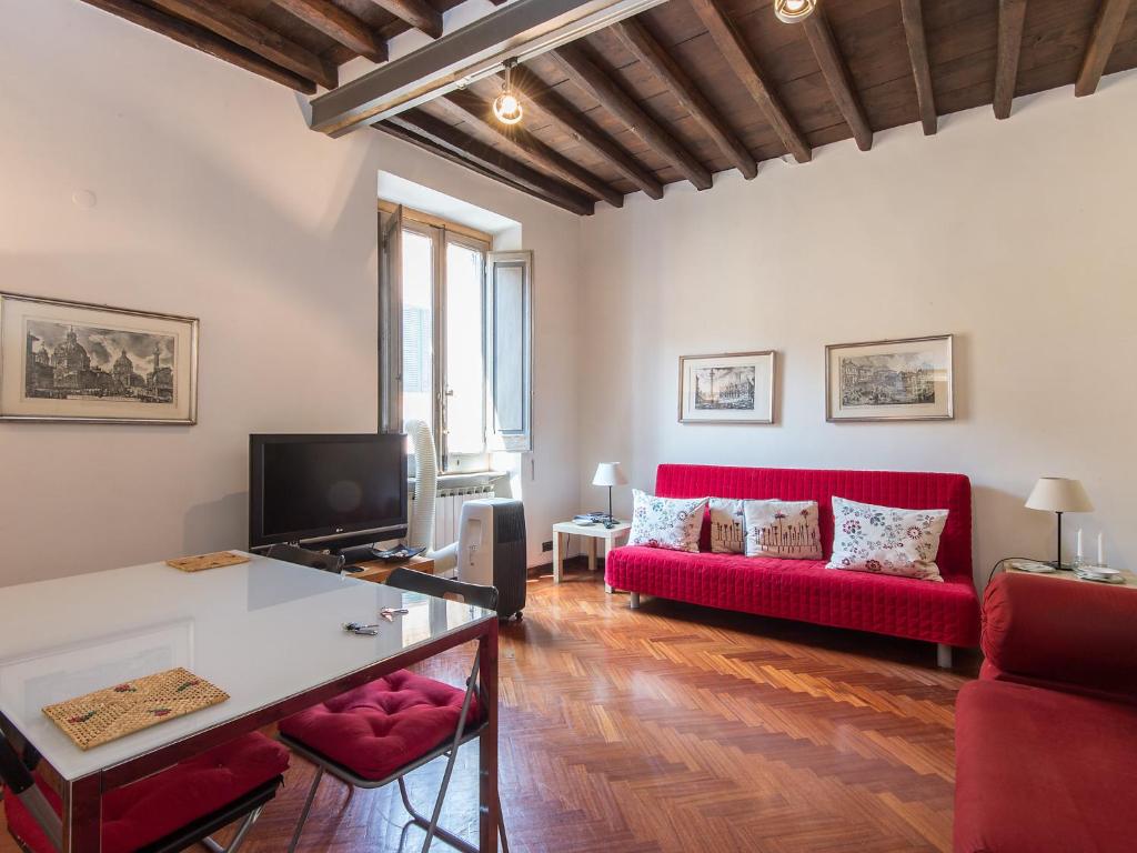 ローマにあるApartment Piazza Navona Charming by Interhomeのリビングルーム(赤いソファ、テレビ付)