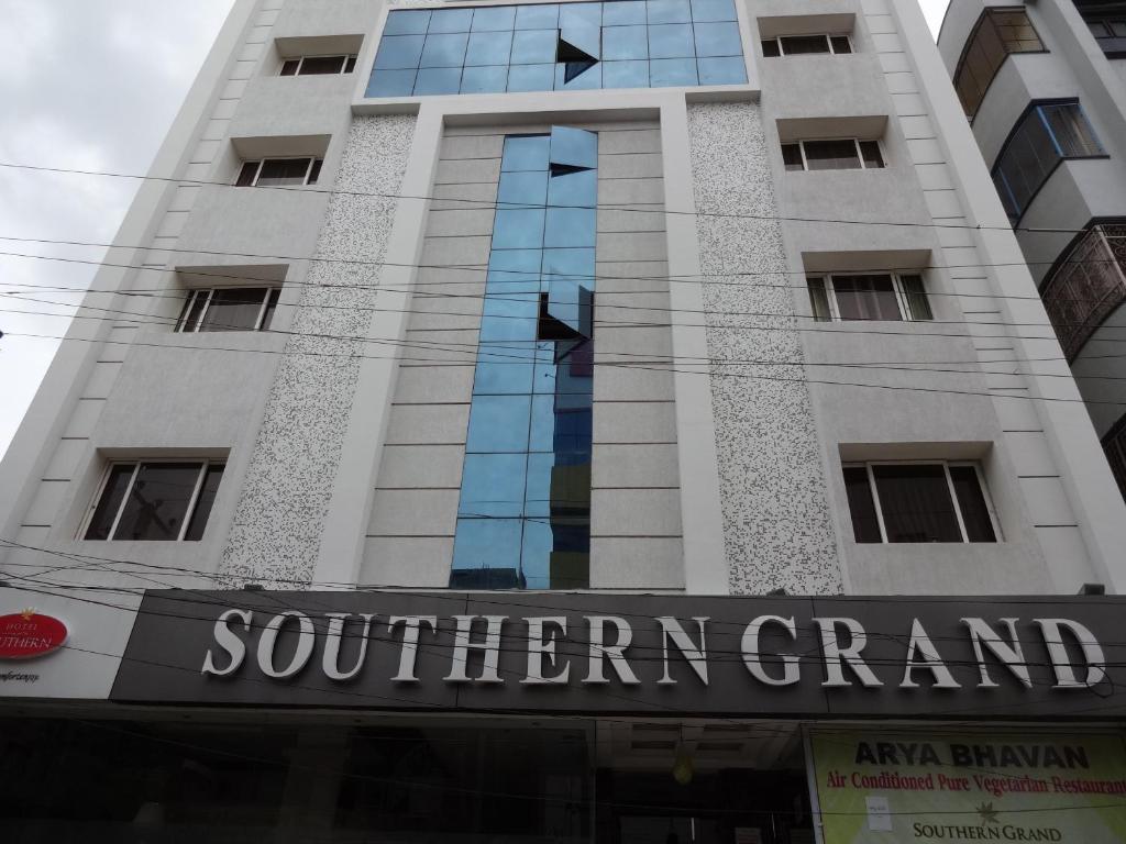 a tall building with a sign for a southern grand at Hotel Southern Grand in Vijayawāda