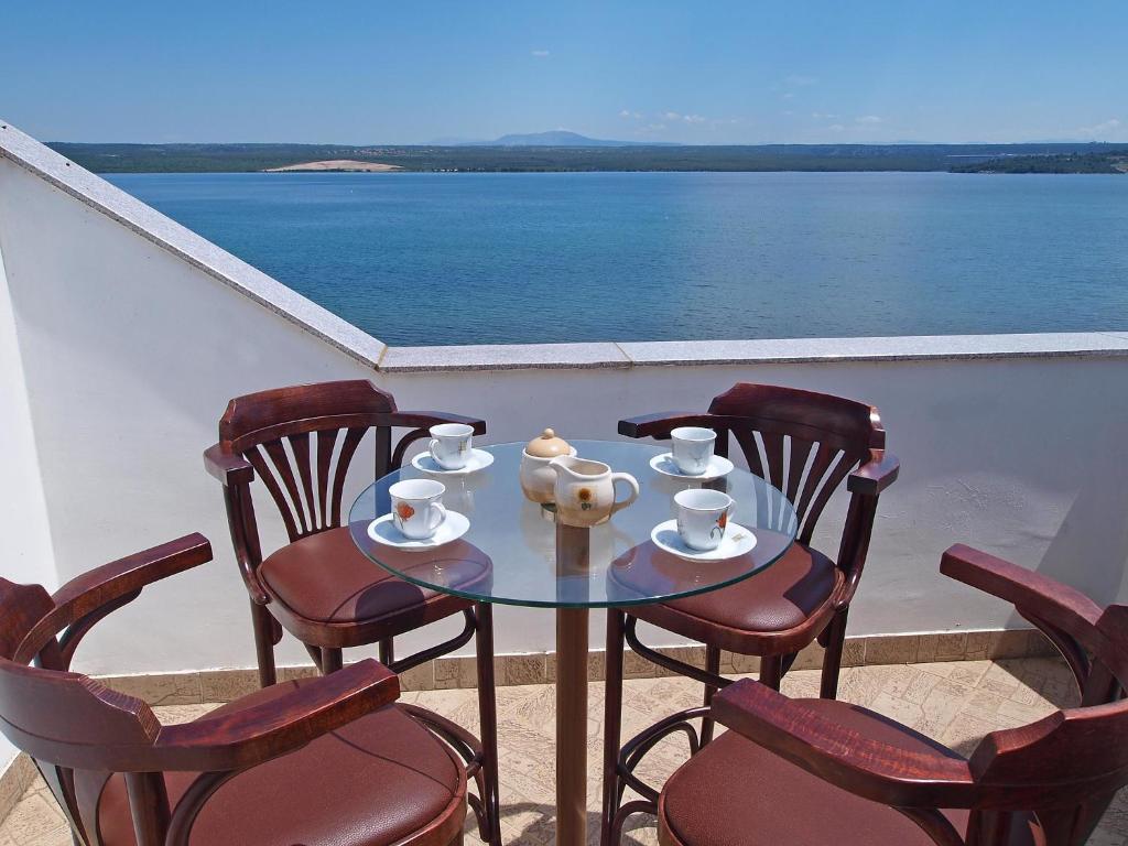 a table and chairs with a view of the water at Apartment Ivana-5 by Interhome in Raslina