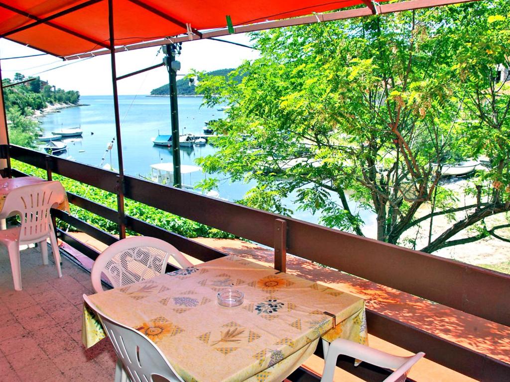 a table and chairs on a balcony with a view of the water at Apartment Šarenko-3 by Interhome in Vela Luka