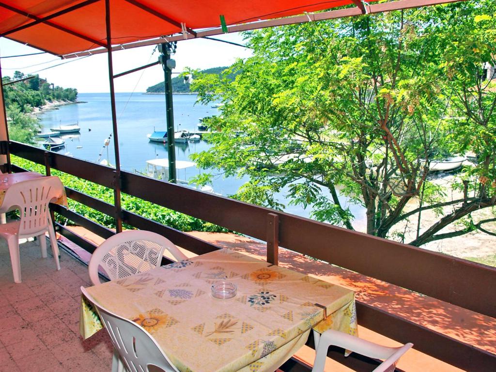 a table and chairs on a balcony with a view of the water at Apartment Šarenko-5 by Interhome in Vela Luka